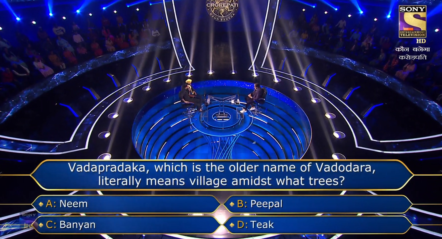 Ques : Vadapradaka, which is the older name of Vadodara, literally means village amidst what trees?